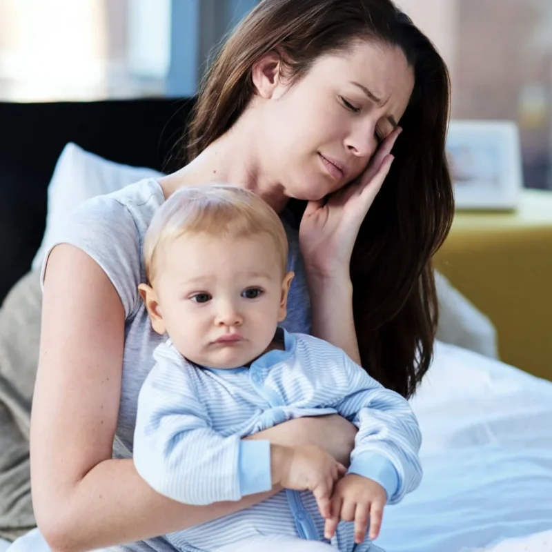 woman with child holding her head