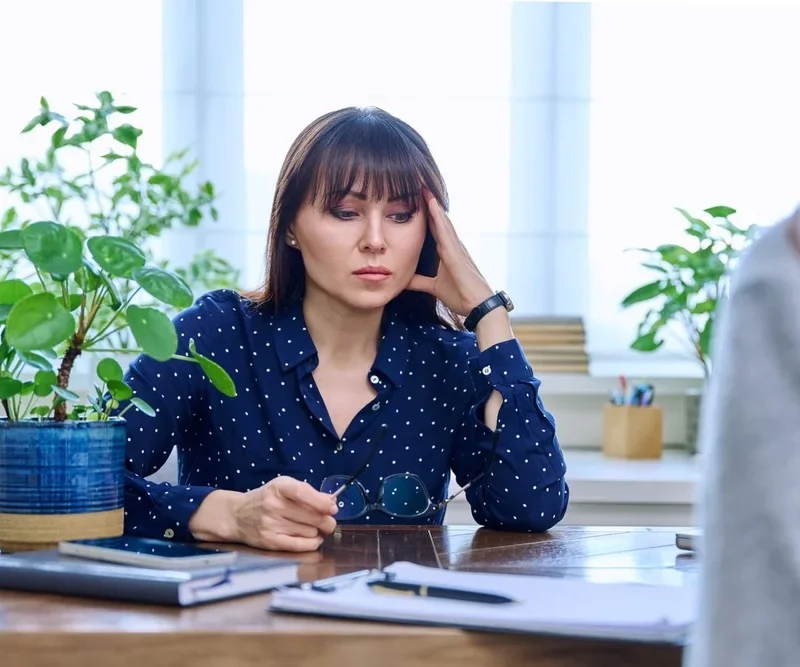 Mature sad woman in therapy session with mental health professional