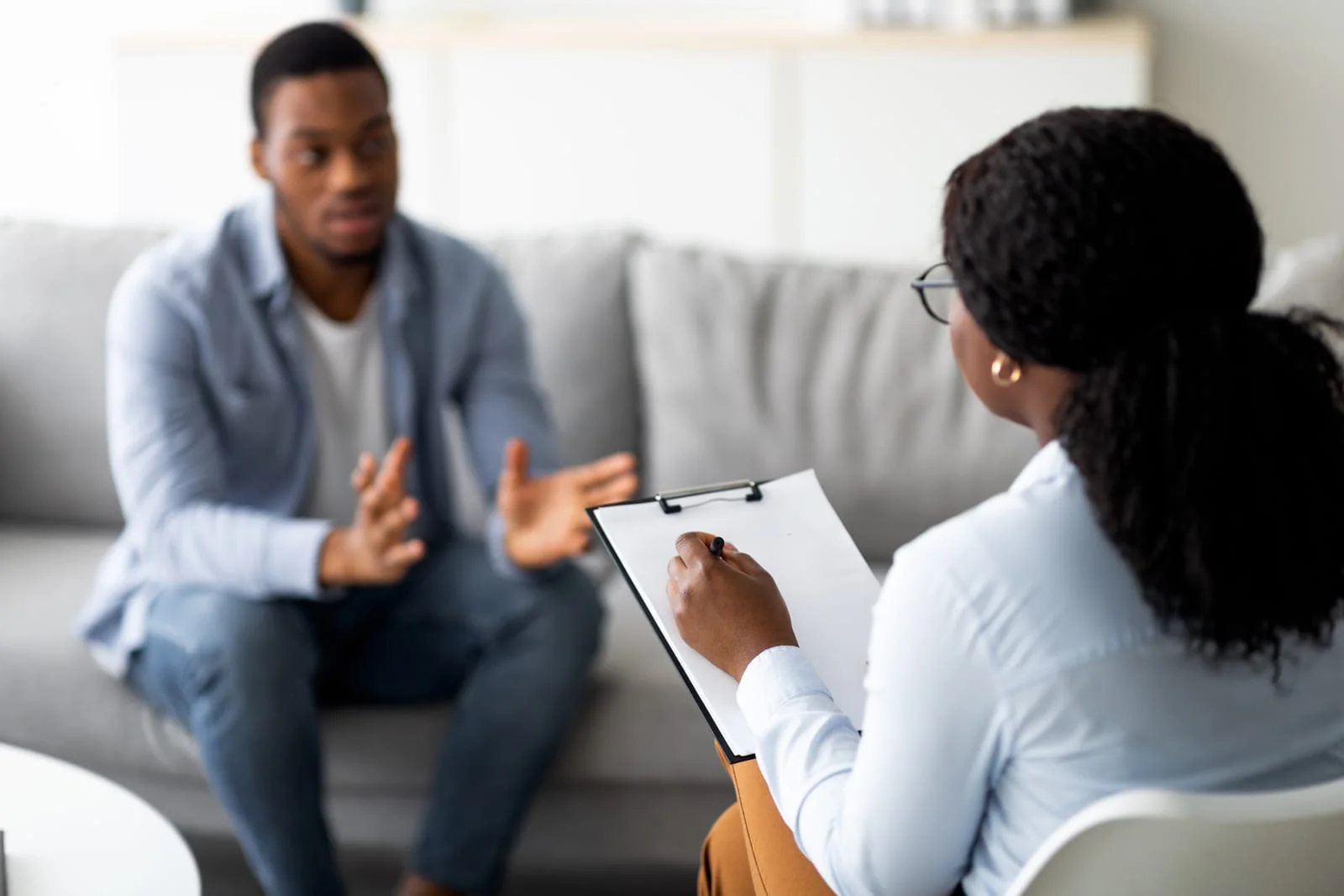 Psychological assistance. Millennial black man with depression having counseling session with therapist at office