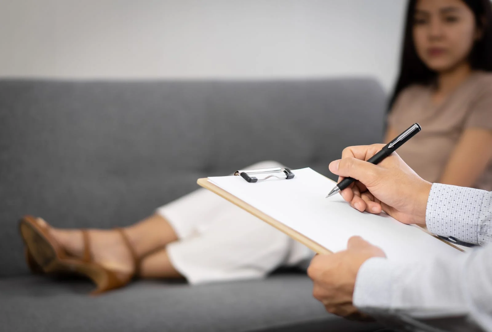Sad woman with depression having consultation with psychiatrist in hospital